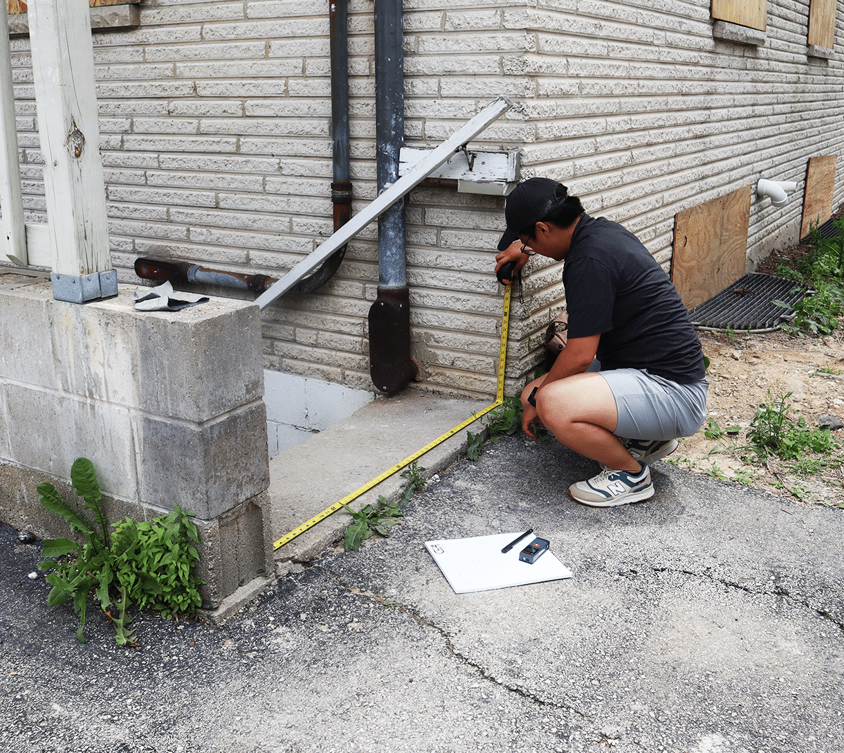 Nhia measuring the width of a staircase.